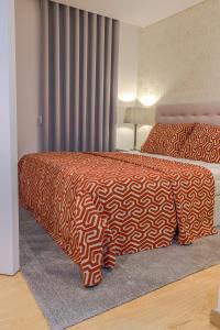 1 dormitorio con 2 camas con sábanas de color naranja y blanco en Bracara Guest House "Arcada", en Braga