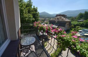 a balcony with a table and chairs and flowers at Apartamenty i Pokoje w centrum Karpacza in Karpacz
