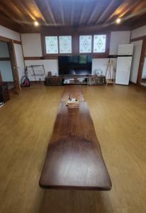 una grande camera con pavimento in legno e TV a schermo piatto di Yangyang 88 Hanok Stay a Yangyang