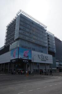 un grand bâtiment en verre avec des personnes qui marchent devant lui dans l'établissement Viru väljak 6 Apartment, à Tallinn