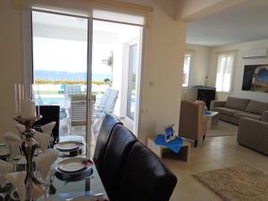 a living room with a couch and a table at Latchi Riviera Beach Villa No.2 in Polis Chrysochous