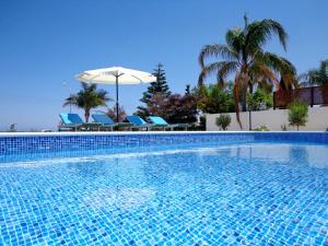 a large swimming pool with chairs and an umbrella at Latchi Riviera Beach Villa No.2 in Polis Chrysochous