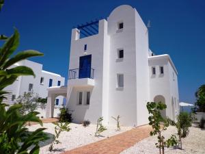a white building with a blue window on it at Latchi Riviera Beach Villa No.2 in Polis Chrysochous