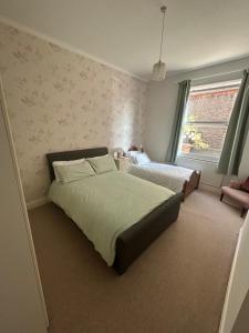 a bedroom with two beds and a window at Banks Road in West Kirby