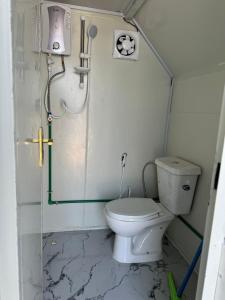 a small bathroom with a toilet and a shower at كرفان السرور على البحر in Half Moon Bay
