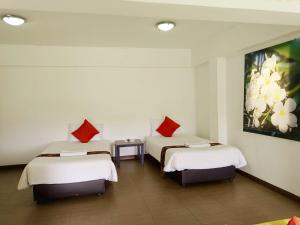 a room with two beds with red pillows at Siam Villa Suvarnabhumi in Ban Khlong Si