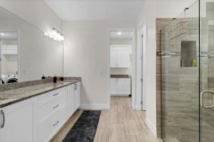 a white bathroom with a glass shower stall at Spacious Suite in modern house in Orlando +11 photos