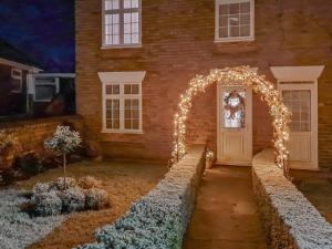 an arch with lights in front of a house at Lavender Cottage in Louth