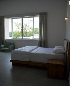 a bedroom with a bed and a large window at Bolgoda Water Estate Villa By CM Holiday in Panadura