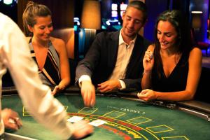a group of people playing roulette at a casino at Troia Design Hotel in Troia