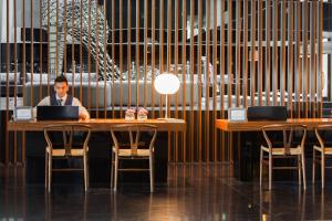 a man sitting at a table with a laptop at Troia Design Hotel in Troia