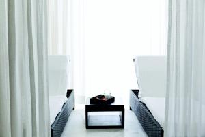 a room with two chairs and a table in front of a window at Troia Design Hotel in Troia
