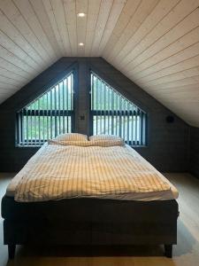 BremnesにあるModern Cabin With Archipelago Viewsの大きな窓のある部屋のベッド