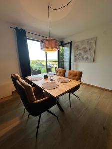 a dining room with a wooden table and chairs at Gemütlich wohnen mit Weinblick in Horrweiler