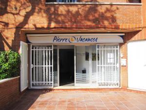 a entrance to a store with a sign on it at Pierre & Vacances Comarruga in Comarruga