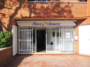 Una entrada a una tienda con un cartel. en Pierre & Vacances Comarruga, en Comarruga