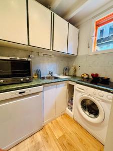 a kitchen with a washing machine and a sink at Maison cap ferret proche des plages in Lège-Cap-Ferret
