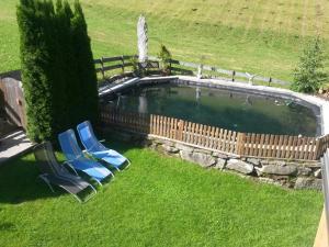 una piscina con 2 sillas y una valla en Haus Enzian, en Mittersill