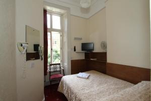 a room with a bed and a phone in it at Ridgemount Hotel in London