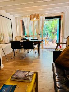 a living room with a table and chairs and a couch at Maison cap ferret proche des plages in Lège-Cap-Ferret