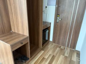 an empty room with a wooden door and a tv at M Bee Hotel in Can Tho