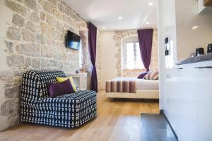 een woonkamer met een stoel en een slaapkamer bij Sir George Luxury Suites in Split