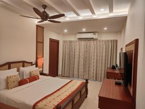 a bedroom with a bed and a ceiling fan at Mohor Kutir Resorts in Bolpur +32 photos