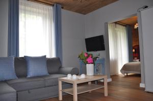 ein Wohnzimmer mit einem Sofa und einem Tisch in der Unterkunft Willa Galicyjska in Muszyna