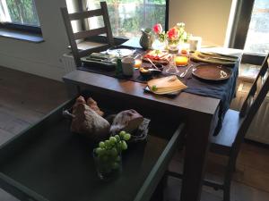 uma mesa com um monte de comida e uvas em Onder de Noot em Baarlo