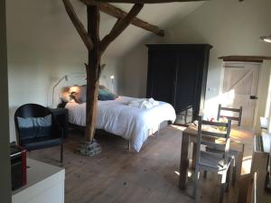a bedroom with a bed and a tree in it at Onder de Noot in Baarlo