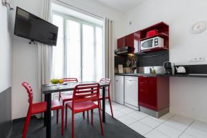 a kitchen with red chairs and a table and a kitchen with a microwave at Nice Appart in Nice