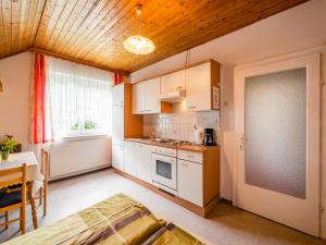 a kitchen with white cabinets and a table at Apartment in Tröpolach near Nassfeld in Tröpolach