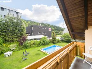 a balcony with a view of a yard with a swimming pool at Apartment in Tröpolach near Nassfeld in Tröpolach