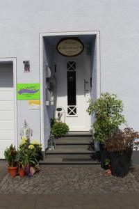 ein weißes Gebäude mit einer weißen Tür und einer Treppe in der Unterkunft Ferienwohnungen Am Bruttiger Moselsteig in Bruttig-Fankel