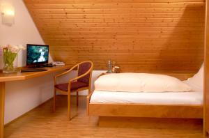 a bedroom with a bed and a desk with a computer at Gasthof Schweizerhof in Villingen-Schwenningen