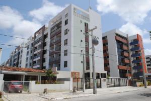 un edificio blanco alto al lado de una calle en Praia do Cabo Branco RV, en João Pessoa
