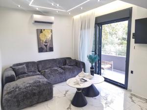a living room with a couch and a table at Endless Blue Seaview in Paleo Tsifliki