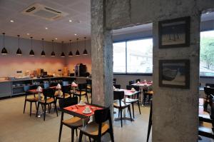 a restaurant with tables and chairs and a counter at Hôtel Le Nautic in Arcachon