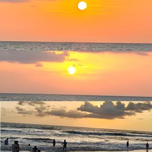 a group of people on the beach at sunset at Gokarna Govekar Sea Facing Rooms in Gokarn