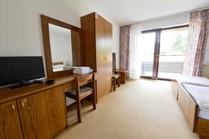 a hotel room with a large window and a television at Guest House Bakhus in Žerjavka