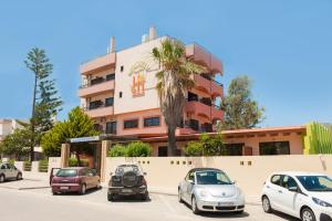 a group of cars parked in a parking lot in front of a building at Heleni Beach Hotel in Ialyssos
