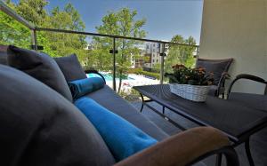 a blue couch on a patio with a table and a window at Apartamenty Bryza in Kołobrzeg