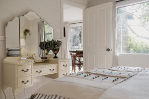 a bedroom with a bed and a dresser and a mirror at The Cottage at Mirador Springs Retreat 