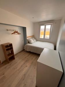 a small bedroom with a bed and a window at Aux Pas Sages, 4 logements mitoyens, proche mer in Saint-Jean-de-Monts