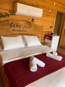 een slaapkamer met een bed met twee handdoeken erop bij Şana Suit Bungalov in Çamlıhemşin +3 foto's