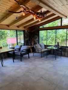 een woonkamer met banken, tafels en ramen bij Şana Suit Bungalov in Çamlıhemşin