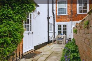 eine Terrasse in einem Haus mit einer weißen Tür in der Unterkunft Hope Cottage - Charming 3 bedroom house, Southwold in Southwold