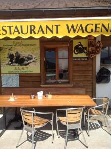 a wooden table and chairs in front of a restaurant at Panorama Hotel Wagenkehr in Innertkirchen