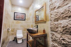 baño con aseo y pared de piedra en Nubi Villas Gili Trawangan, en Gili Trawangan 27 fotos más