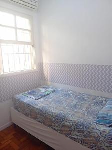 Ce lit se trouve dans un dortoir doté d'une fenêtre et d'un couvre-lit. dans l'établissement Big H Homes Brooklin Paulista e Vila Olimpia, à São Paulo